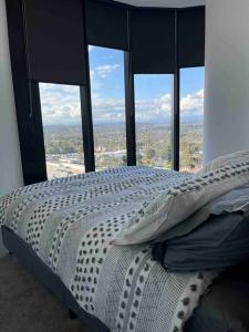 a bedroom with a bed in front of a window at Top Floor Mountain View Luxury Rental Unit in SkyGarden Glen in Glen Waverley