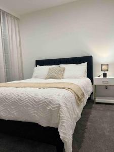a bedroom with a large bed with a black headboard at Top Floor Mountain View Luxury Rental Unit in SkyGarden Glen in Glen Waverley