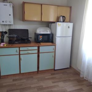 een keuken met een witte koelkast en een magnetron bij уют in Rustavi