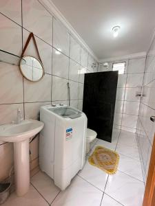 a white bathroom with a sink and a toilet at Casa toda - Praia Barra do Sahy - Aracruz in Aracruz