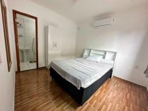 a bedroom with a bed and a bathroom with a shower at Casa toda - Praia Barra do Sahy - Aracruz in Aracruz