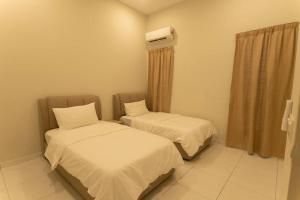 Cette chambre dispose de deux lits et de la climatisation. dans l'établissement Krubong Bungalow Homestay [WiFi equipped], à Kampong Kerubong