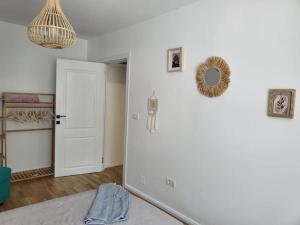 um quarto com uma cama e uma parede branca em Concordia - apartament nou amenajat - lângã Cazino em Băile Herculane