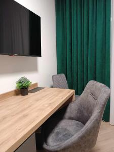 a desk with a chair and a television in a room at Apartamenty Centrum in Janów Lubelski