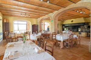 Tenuta Di Corbara في Corbara: غرفة طعام مع طاولات وكراسي مع مفارش بيضاء