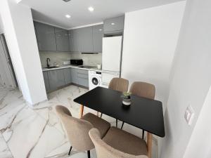 una cocina con mesa negra y sillas en Calpe apartamento lujoso bajo terasa piscina aire cerca playa pueblo, en Calpe