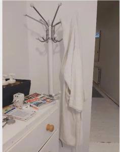 a white robe hanging on a wall next to a counter at Centrel to london single bed room quiet home with host and breakfast in London