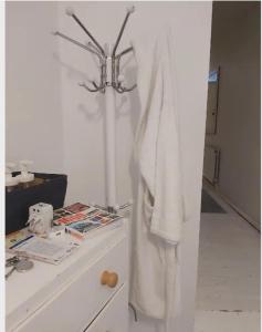 a white robe hanging on a wall next to a counter at Centrel to london single bed room quiet home with host and breakfast in London +3 photos