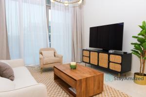 a living room with a tv and a coffee table at Amazing 2 BR in The Polo Residence Meydan in Dubai