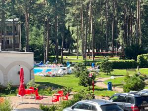 a park with a pool and tables and chairs at Amber Blue Mare in Łukęcin