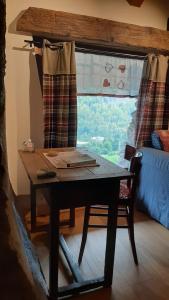 einen Tisch und einen Stuhl in einem Zimmer mit Fenster in der Unterkunft Il canto del bosco in Valpelline