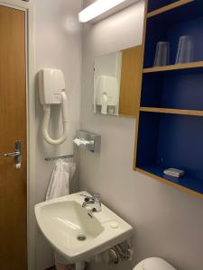łazienka z umywalką i telefonem na ścianie w obiekcie Dovre Motell w mieście Dovre