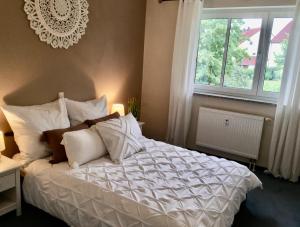 ein Schlafzimmer mit einem weißen Bett und einem Fenster in der Unterkunft Schöne Gartenwohnung im Seenland in Wackersdorf