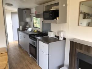 a kitchen with white cabinets and a stove top oven at Dotty at Seawick 106 in Jaywick Sands