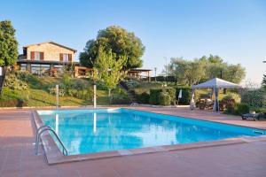 une grande piscine avec une maison en arrière-plan dans l'établissement Tenuta Di Corbara, à Corbara