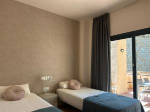 Habitación de hotel con 2 camas y ventana en Quite & relaxing private apartment for 2-6 pers - Golf & Pool resort - Murcia, en Murcia