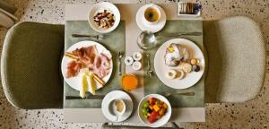 einen Tisch mit Teller mit Speisen und Tassen Kaffee in der Unterkunft Maison Boutique Al Redentore in Venedig