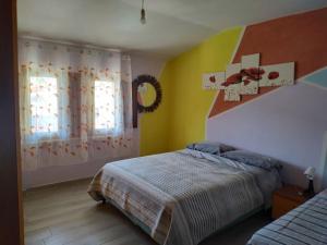 1 dormitorio con cama, paredes amarillas y ventana en Appartamento in Garfagnana, en Castelnuovo di Garfagnana
