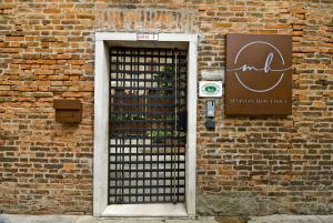 a door with a black gate in a brick wall at Maison Boutique Al Redentore in Venice