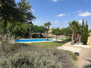 una piscina en un complejo con palmeras en Quite & relaxing private apartment for 2-6 pers - Golf & Pool resort - Murcia, en Murcia