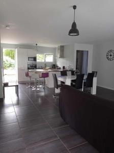 een keuken en een woonkamer met een tafel en stoelen bij Maison neuve au calme avec jardin in Gaillan-en-Médoc