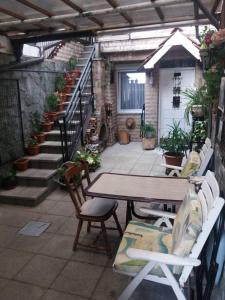 eine Terrasse mit einem Tisch, Stühlen und Treppen in der Unterkunft Apartment Reni in Sarajevo