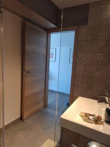 a bathroom with a sink and a glass door at Ob Potoku 