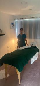 una mujer de pie junto a una cama en una habitación en Sea Vista Boutique Accommodation en Fahan