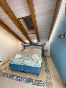 1 dormitorio con cama azul y techo de madera en Bed&Breakfast Miramare en Agerola