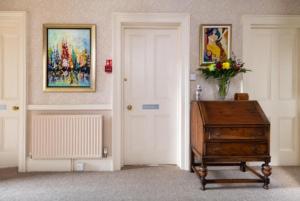 Habitación con puerta, mesa y pintura en Highcliffe House, en Lynton