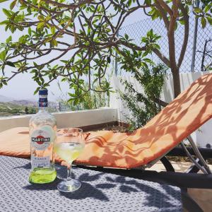 a glass of white wine and a bottle on a table at LA CASA DEL ALMÁCIGO in Arona