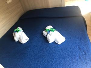 2 Handtücher auf einem Bett mit blauem Laken in der Unterkunft Villa Luisa in Tropea