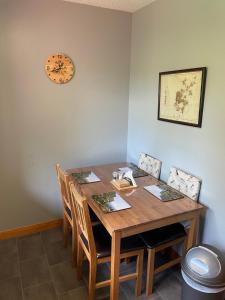 a dining room table with chairs and a clock on the wall at 8 Jib Park, Finstown in Finstown