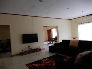 a living room with a couch and a flat screen tv at Quest in Lilongwe