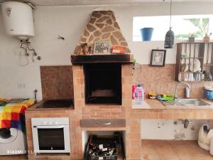 アロナにあるLA CASA DEL ALMÁCIGOのキッチン(中央にレンガ造りの暖炉付)