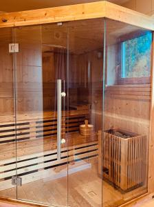 una sauna con un recinto de cristal en una cabaña en To Tu Dom, en Brenna