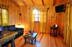 een woonkamer met een bank en een tafel bij Terra Lodge in Puerto Iguazú