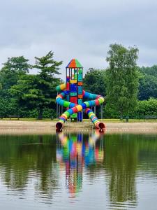 RijkevorselにあるVakantiepark Breebos: Empty Lots for tents and mobile homesの水の流れる横の公園内のウォータースライド