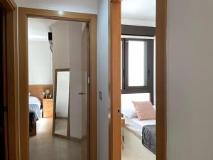 Una habitación con un dormitorio con una cama y un espejo. en Taima Flats 3, en Alicante
