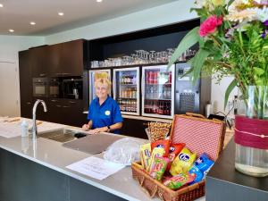 a woman standing behind a counter in a kitchen at Vakantiepark Breebos: Empty Lots for tents and mobile homes in Rijkevorsel