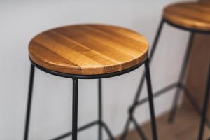 a wooden stool sitting next to two stools at VOYA NORDIC Apartment-a luxury oasis in the old town in Braşov