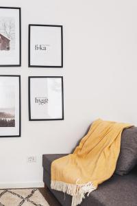 a room with pictures on a wall with a couch at VOYA NORDIC Apartment-a luxury oasis in the old town in Braşov