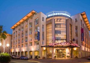 a large building with a mercure hotel at Magnifique 4 pers plage à pied in Fréjus