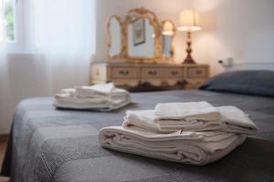 una pila de toallas sentadas en una cama con espejo en Villa Anna Bolgheri, en Bolgheri