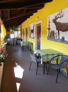 un patio con mesas, sillas y animales en la pared en Bed and Breakfast Špelca, en Pivka