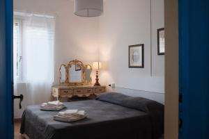 1 dormitorio con cama y espejo en Villa Anna Bolgheri, en Bolgheri