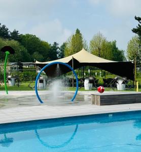 uma piscina com uma fonte em frente a uma tenda em Vakantiepark Breebos: Empty Lots for tents and mobile homes em Rijkevorsel