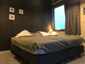 een groot bed in een slaapkamer met een raam bij Grysperre B&B in Hooglede