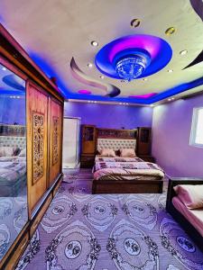 a bedroom with two beds and a purple ceiling at Wadi rum village bed and breakfast in Wadi Rum