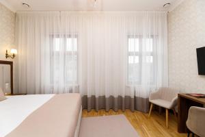 una camera da letto con un grande letto bianco e una finestra di Feder Boutique Hotel a Lviv